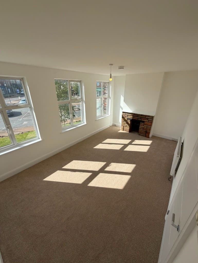 Same living room after AHRK refurbishment, with fresh décor and new flooring
